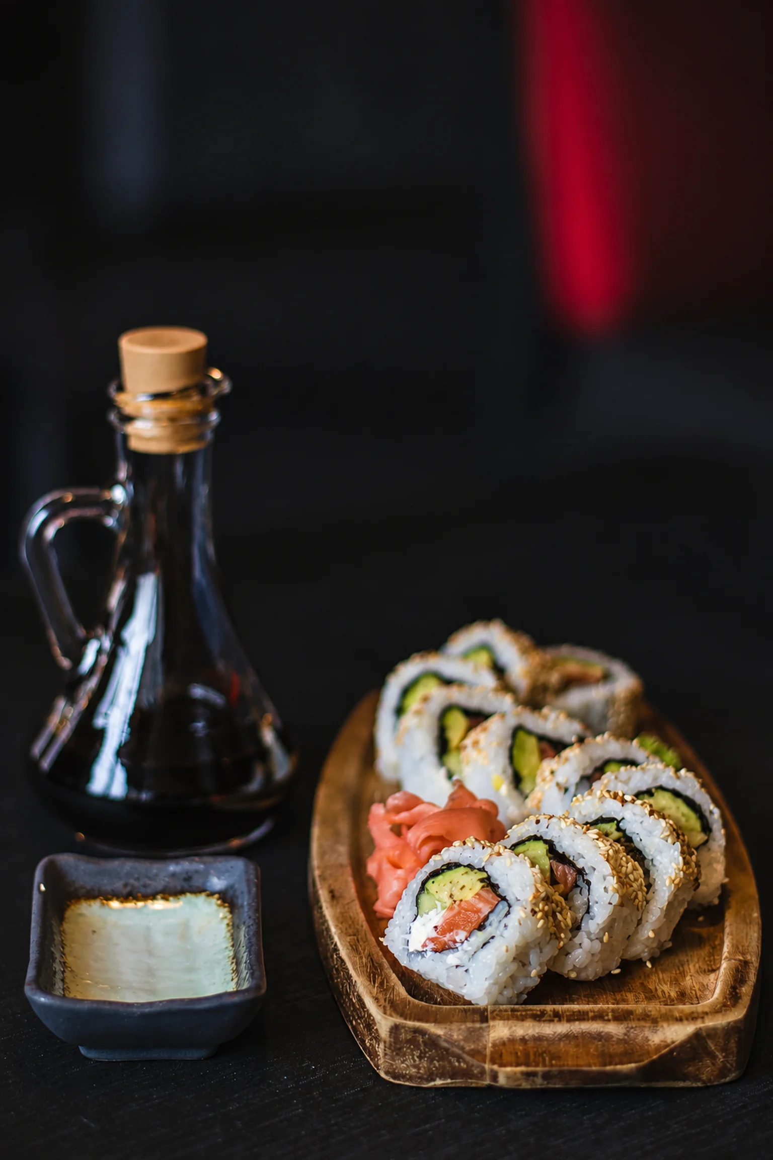 Maki in a dish and a bottle against a dark background — illustration